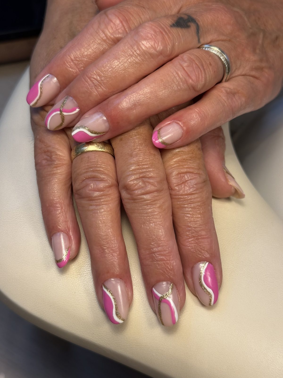 Nude nagels met roze en witte swirls als nail art